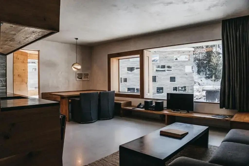 Wohnzimmer mit großen Fenstern und moderner Ausstattung