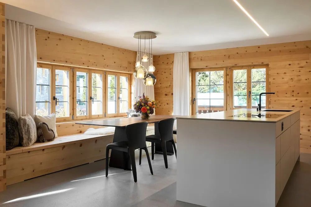 Heller Essbereich mit Holztisch beleuchtet von Designerleuchten