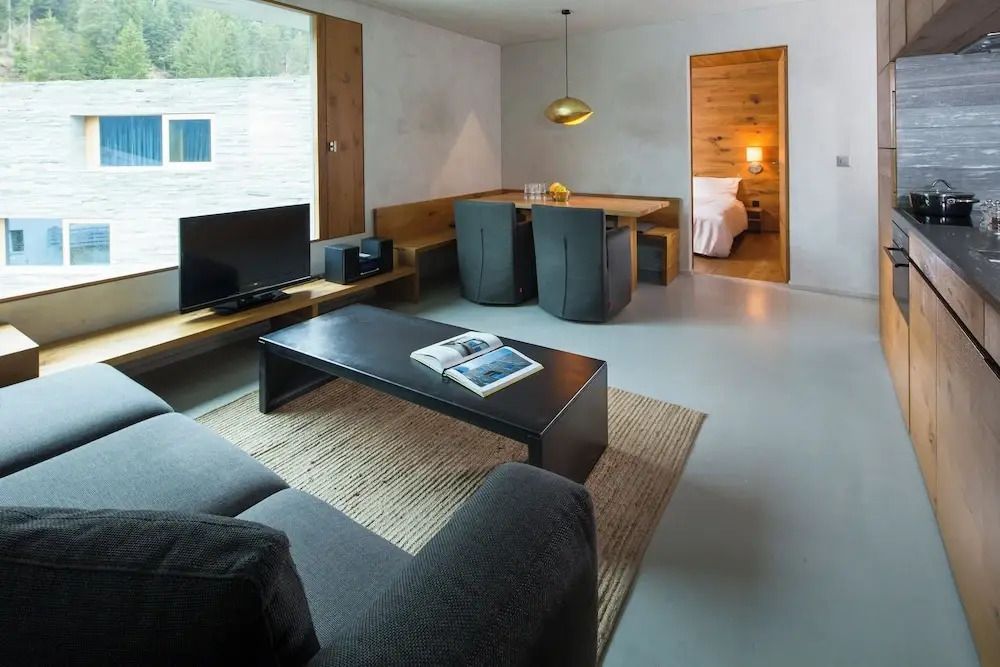 Wohnzimmer mit TV und gemütlicher Sitzecke neben Essbereich