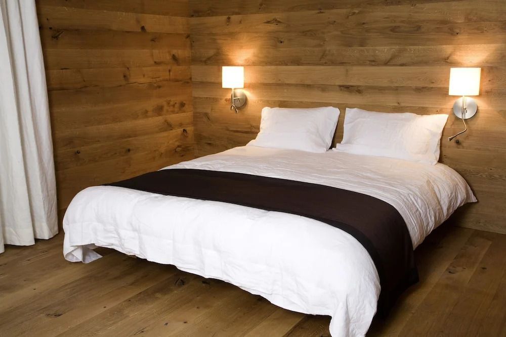 Schlafzimmer mit Holzverkleidung und gemütlichem Doppelbett