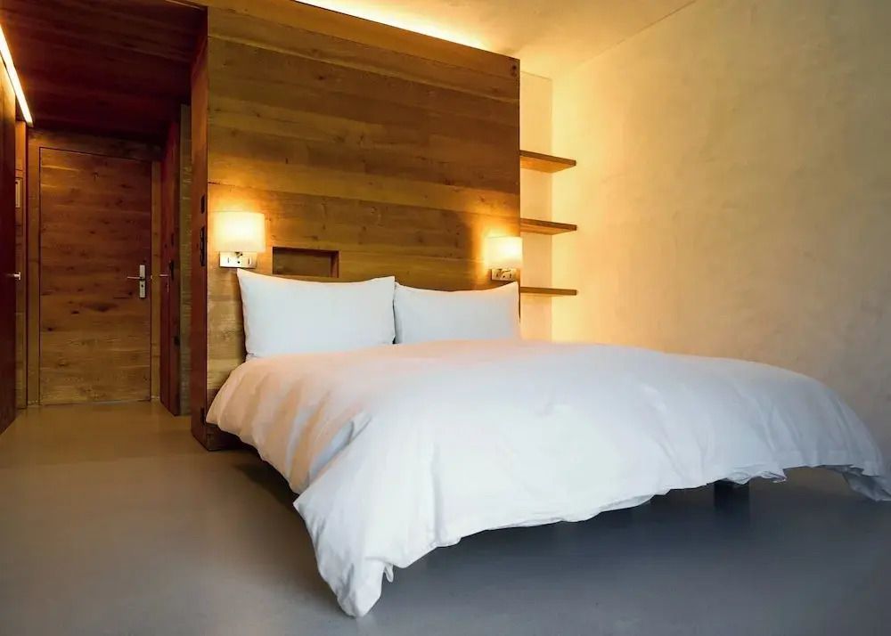 Komfortables Doppelbett mit Holzakzenten und minimalistischem Design im Hotelzimmer