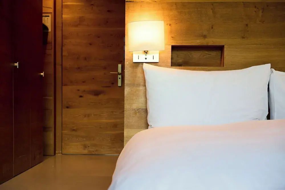 Elegantes Schlafzimmer mit Holzverkleidung und dezenter Beleuchtung