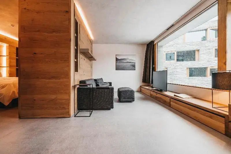 Wohnbereich mit großem Panoramafenster und Rattansofa