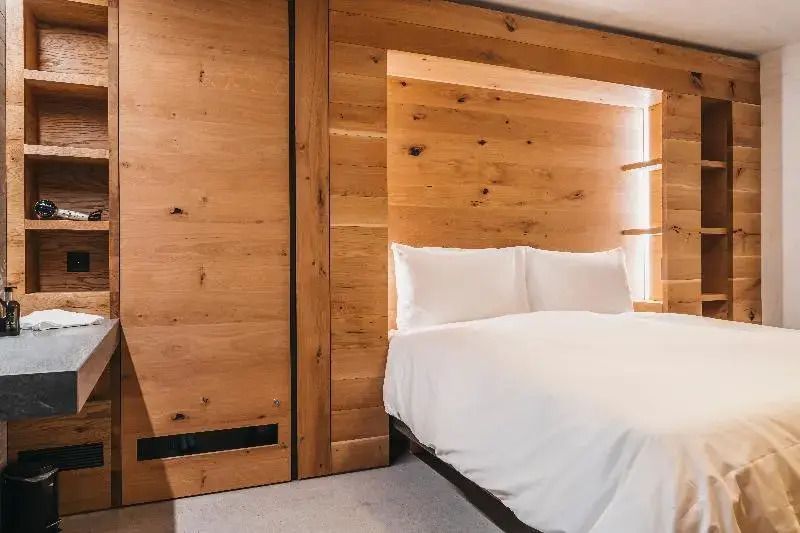 Schlafbereich mit Doppelbett und Holzverkleidung