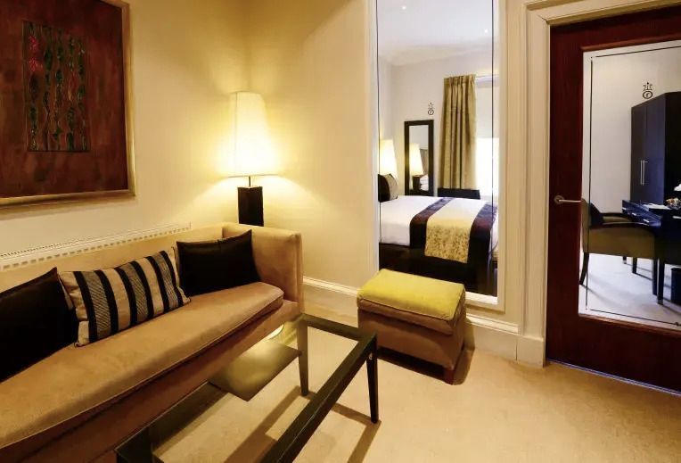Gemütlicher Wohnbereich mit Sofa und Lampen im Hotelzimmer