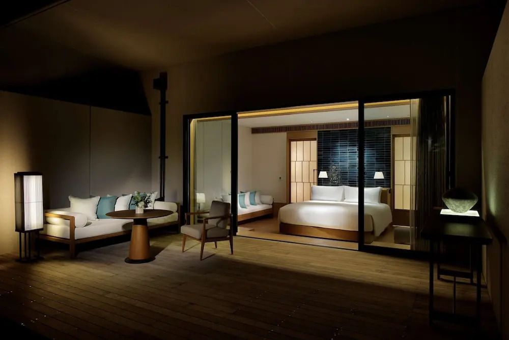 Stilvolles Zimmer bei Nacht mit Sitzbereich und Terrassenzugang