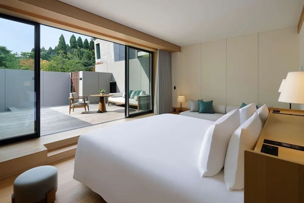 Hotelzimmerinterieur mit Blick von Bett auf die Terrasse