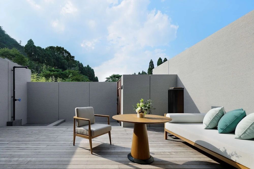 Private Terrasse mit Tisch, Stuhl und Sofa unter blauem Himmel