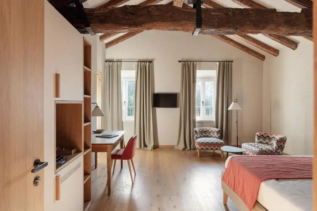 Geräumiges Zimmer mit Fenster, Holzbalkendecke und moderner Einrichtung in der Suite.