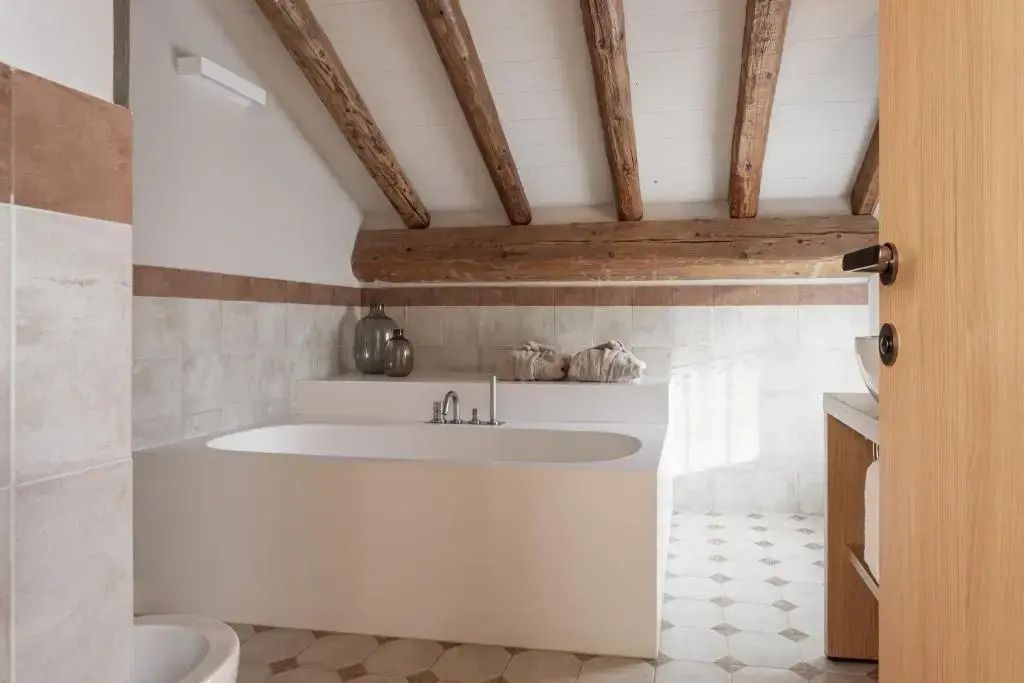 Modernes Badezimmer mit freistehender Badewanne und Holzbalkendecke.