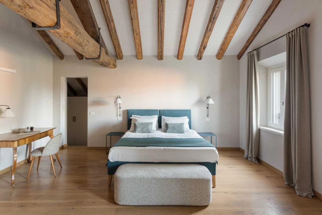 Helle Suite mit Holzbalkendecke und Doppelbett