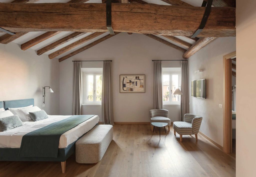 Große Suite mit Sitzbereich und Holzbalkendecke