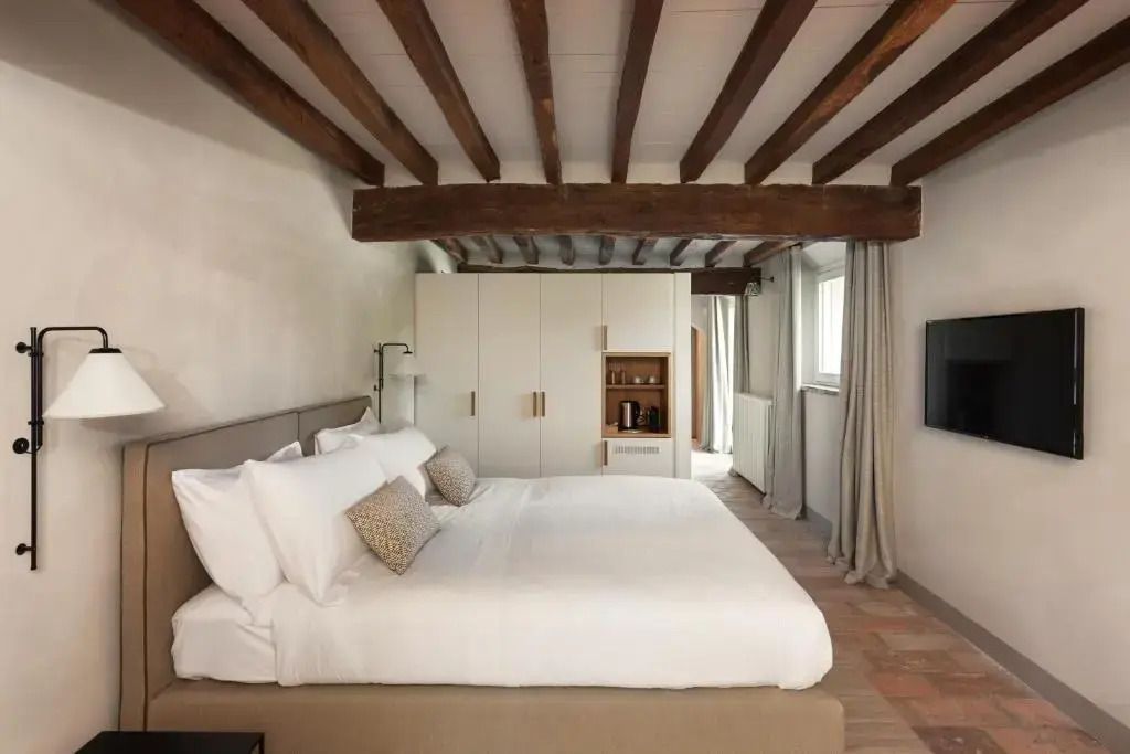 Elegantes Schlafzimmer mit Holzbalkendecke und modernem Doppelbett