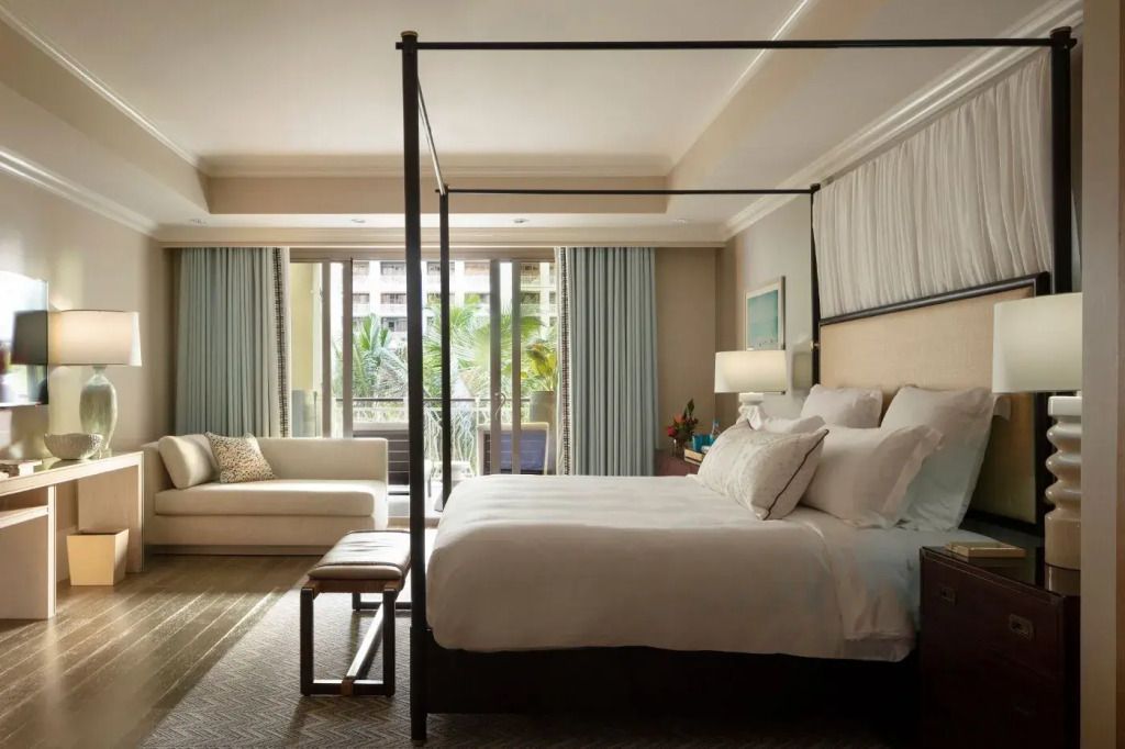 Raffinierte Suite mit Doppelbett, heller Beleuchtung und Balkon mit Meeresblick.