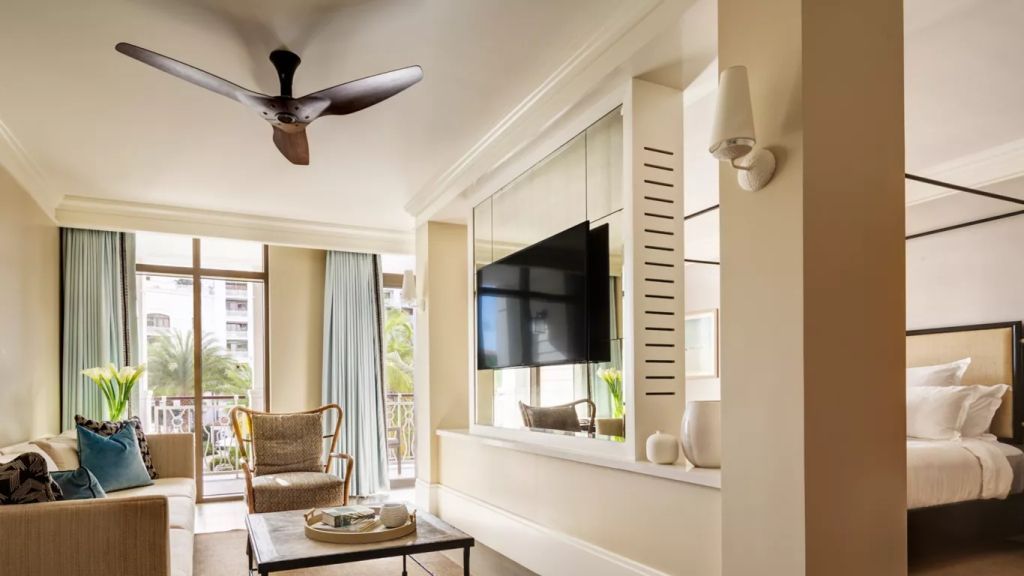 Moderne Suite mit Sitzbereich und Flachbildfernseher vor großen Fenstern