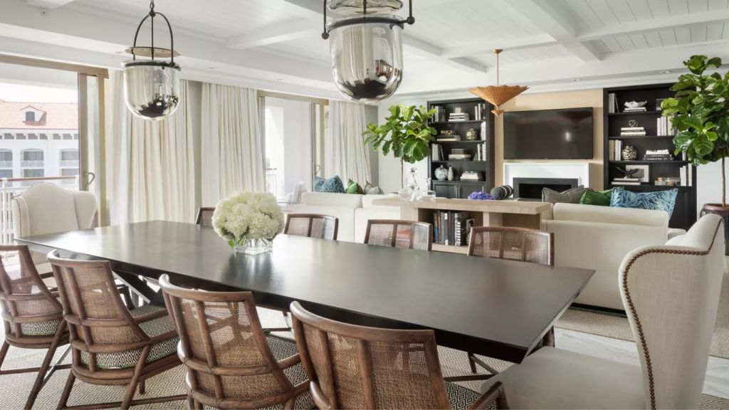 Essbereich mit großem Tisch und eleganten Korbstühlen im Penthouse.