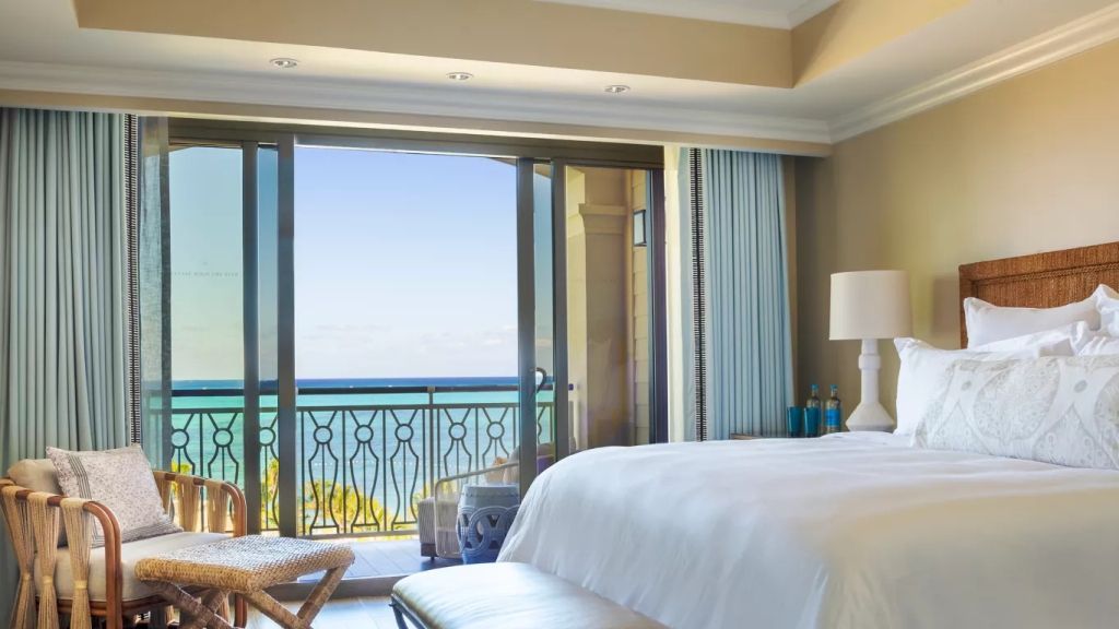 Helles Schlafzimmer mit Panoramablick auf das Meer und direktem Zugang zum Balkon.
