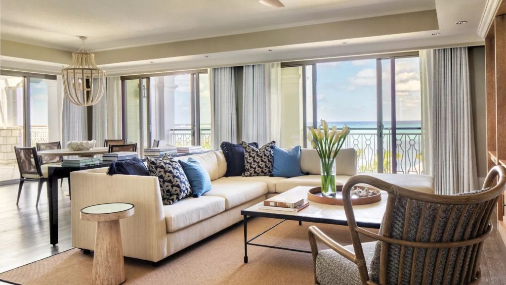 Geräumiges Wohnzimmer mit großen Fenstern und Blick auf das Meer.