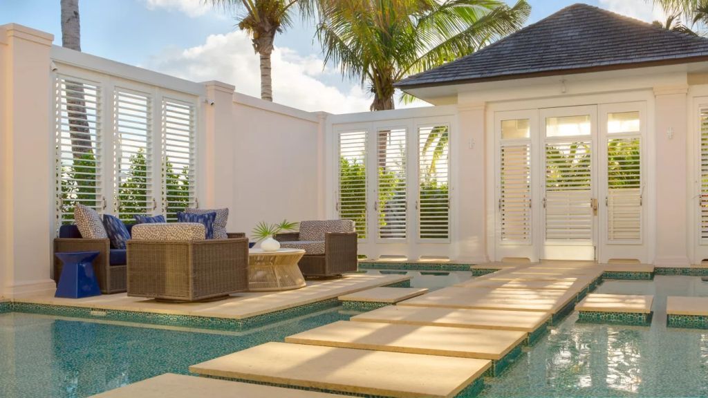 Privater Poolbereich der Villa mit stilvollen Outdoor-Möbeln und Palmen im Hintergrund