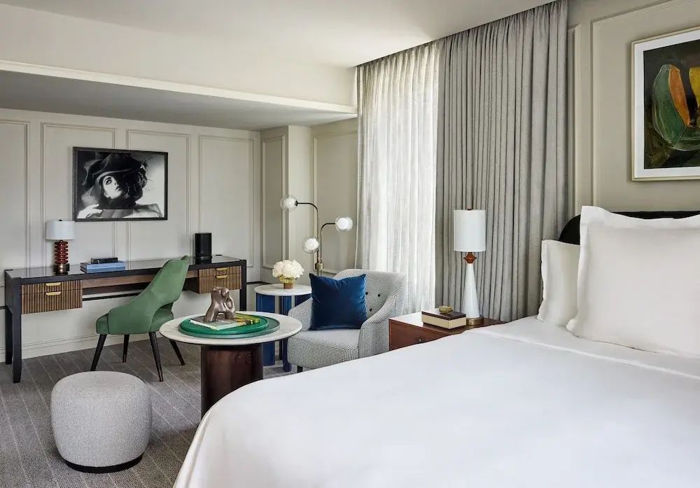 Geräumiges Deluxe-Zimmer mit Schreibtisch und luxuriösem Bett im Hotel