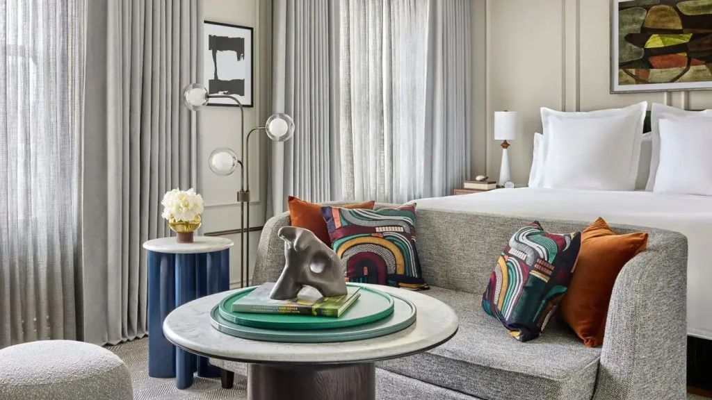 Elegantes Doppelzimmer mit modernem Dekor und Kunstwerken an den Wänden
