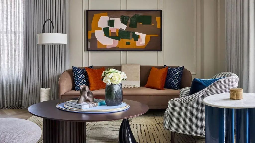 Wohnbereich mit elegantem Sofa, farbigen Kissen und moderner Kunst an der Wand