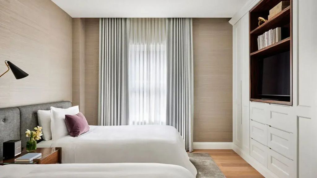 Helles Schlafzimmer mit elegantem Doppelbett und Vorhängen in der Lord Stanley Suite.