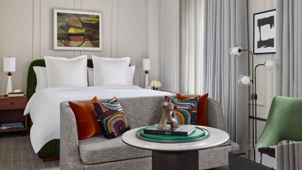 Elegantes Hotelzimmer mit Doppelbett und stilvoll dekorierten Kissen.