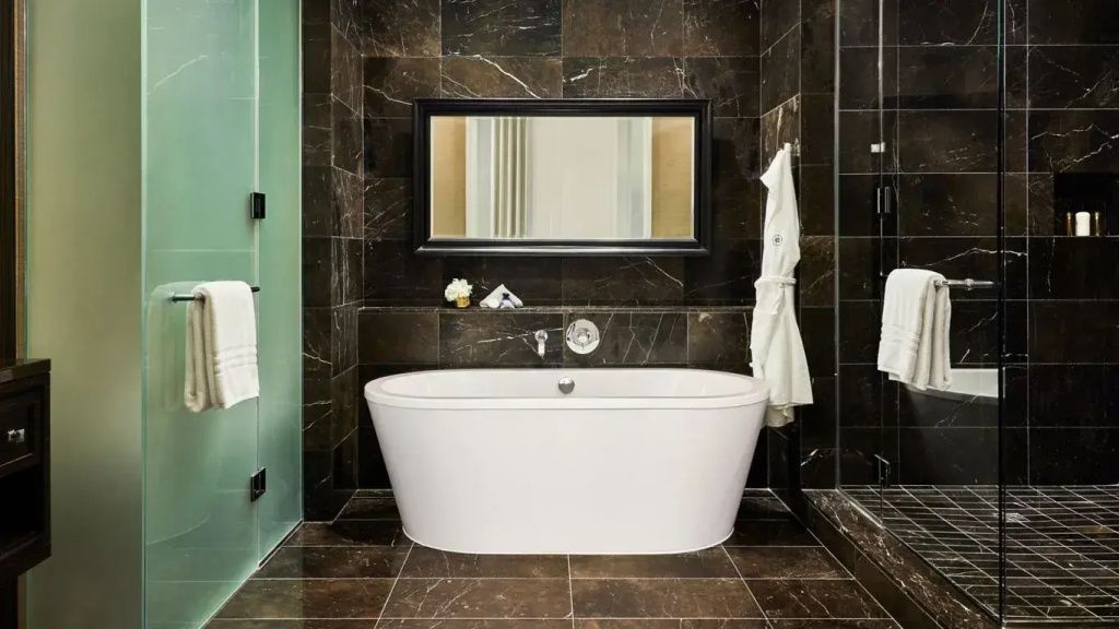 Modernes Badezimmer mit freistehender Badewanne und dunklen Fliesen