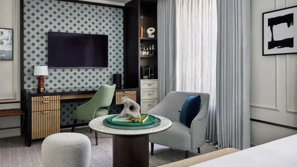 Modernes Hotelzimmer mit Schreibtisch, gemütlichem Sessel und stilvoller Dekoration.
