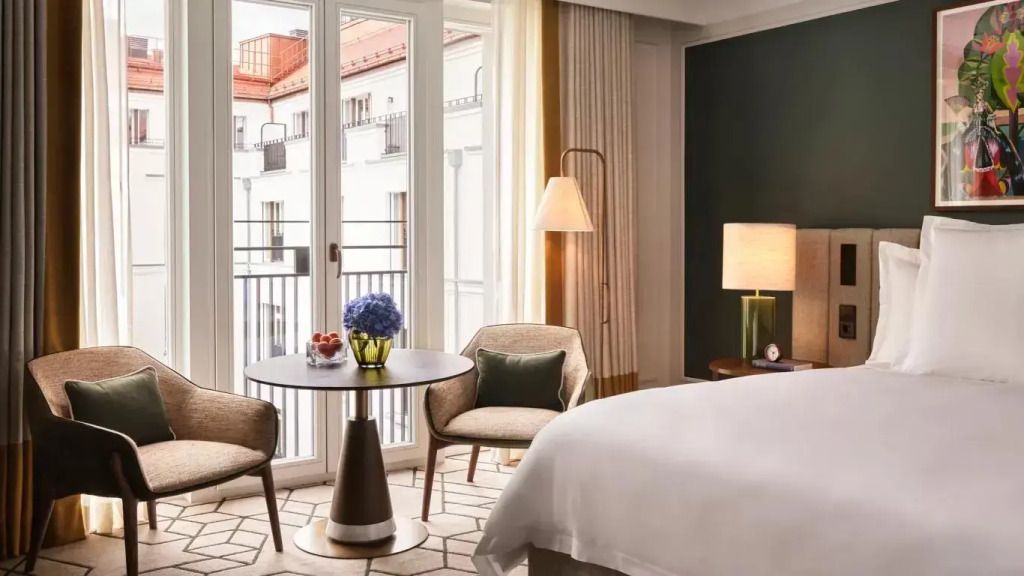 Heller Sitzbereich mit Balkonzugang und gemütlichen Sesseln im Deluxe Doppelzimmer.