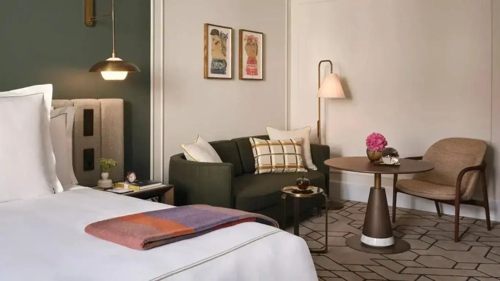Gemütlicher Sitzbereich in der Junior-Suite mit Sofa und Kunstwerken an der Wand.