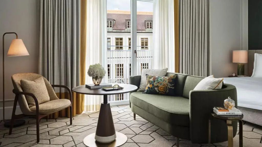 Gemütlicher Loungebereich mit modernem Sofa und Blick auf historische Architektur