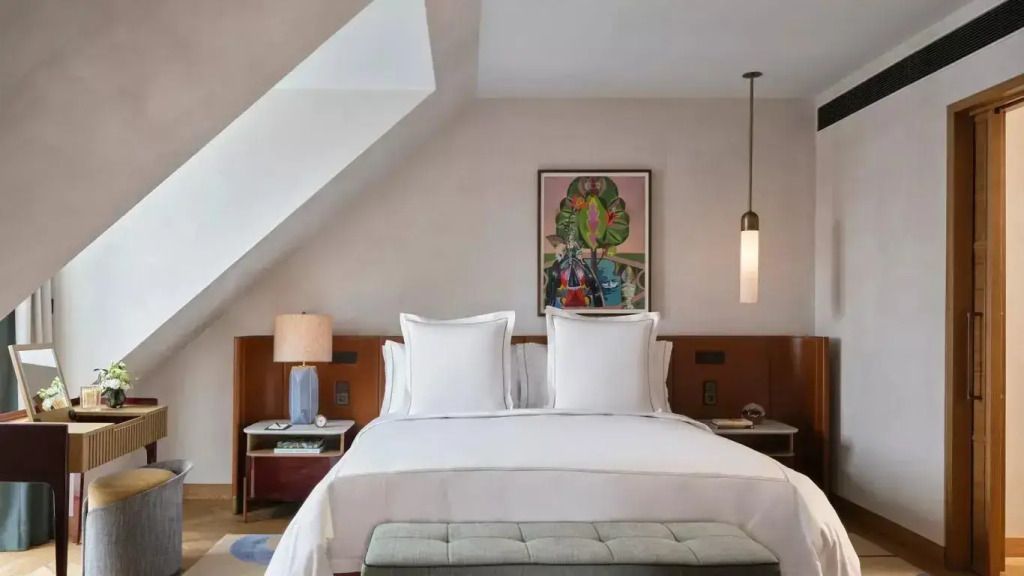 Elegantes Doppelzimmer im Dachgeschoss mit Kunstwerk über dem Bett