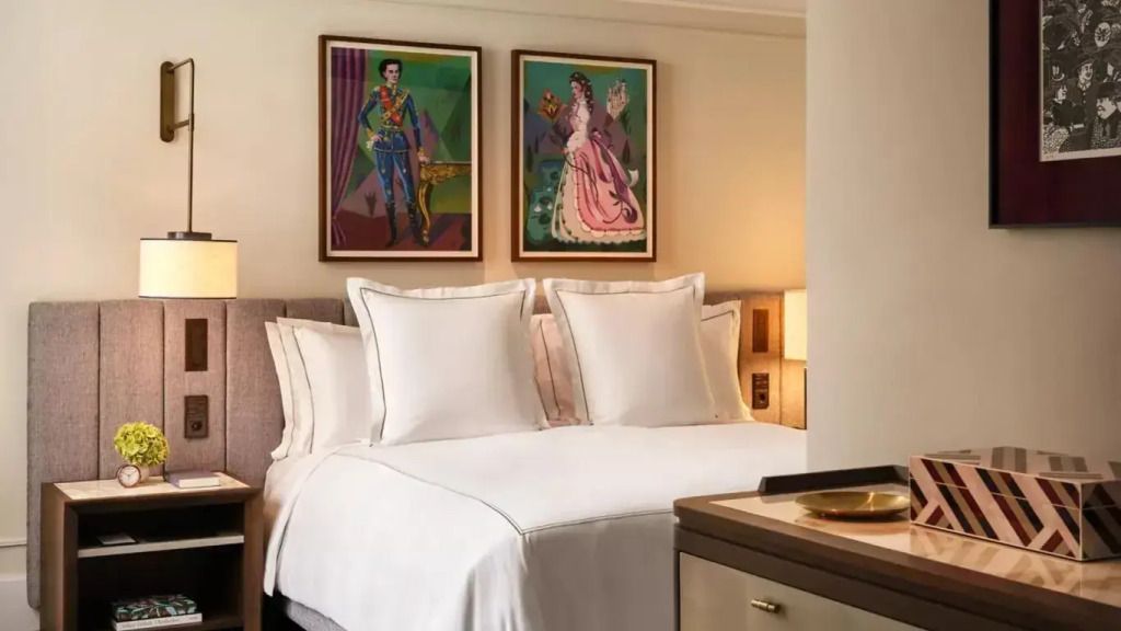 Elegantes Schlafzimmer mit Doppelbett und modernen Kunstwerken an der Wand.