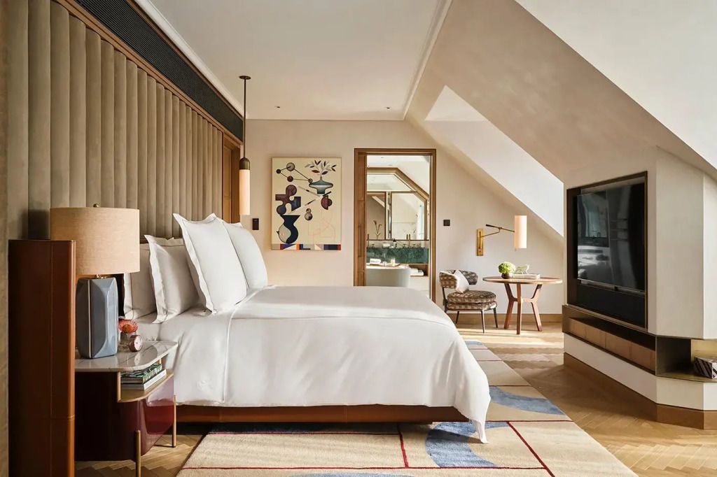 Elegantes Doppelbett in einem hellen Zimmer mit schrägem Dachfenster