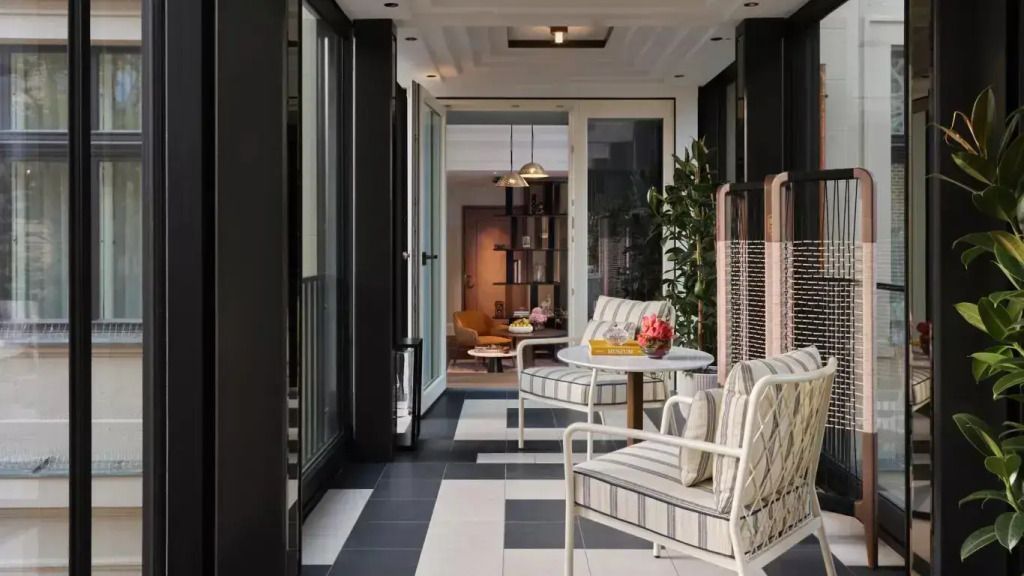 Heller Korridor mit eleganten Sitzgelegenheiten und Pflanzen im Rosewood Munich