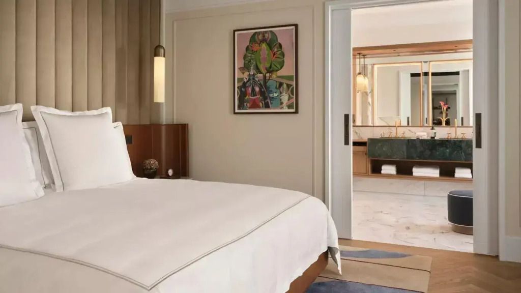 Elegantes Schlafzimmer mit Doppelbett und Blick ins stilvolle Badezimmer