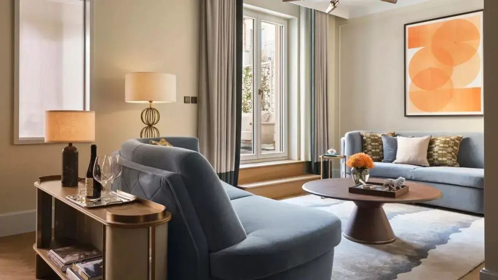 Gemütlicher Wohnbereich mit zwei blauen Sofas und großer Fensterfront