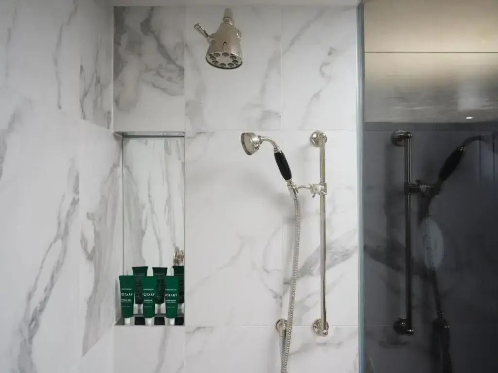Moderne Dusche im Deluxe Badezimmer mit Marmorwänden und Regendusche
