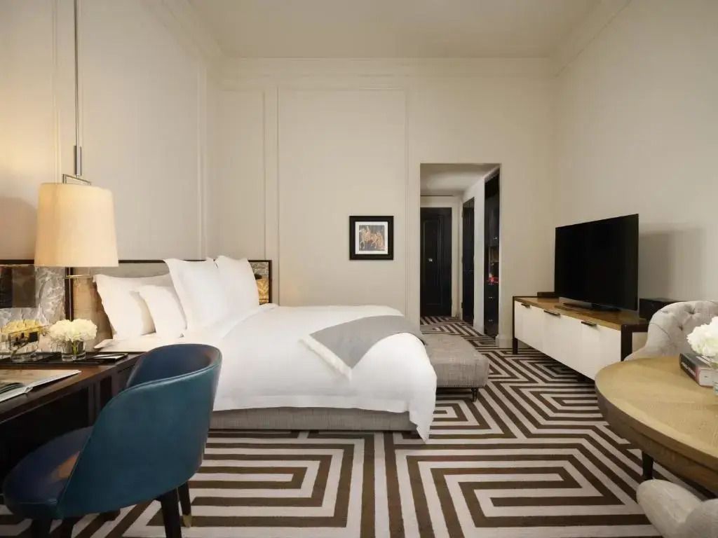 Executive Doppelzimmer mit elegantem Teppichmuster und großem Fernseher