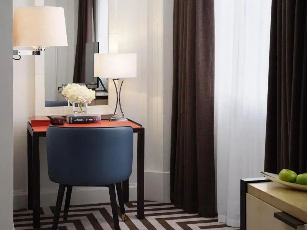 Kompakter Schreibtisch mit Lampe und dekorativen Elementen im Hotelzimmer