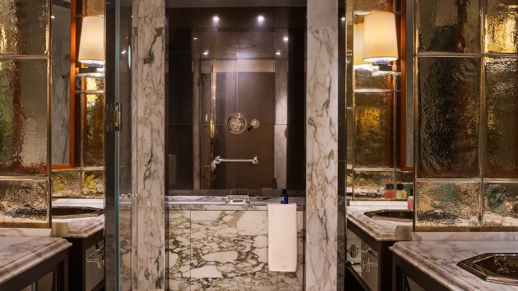 Luxuriöses Badezimmer mit Marmorakzenten und edler Beleuchtung.