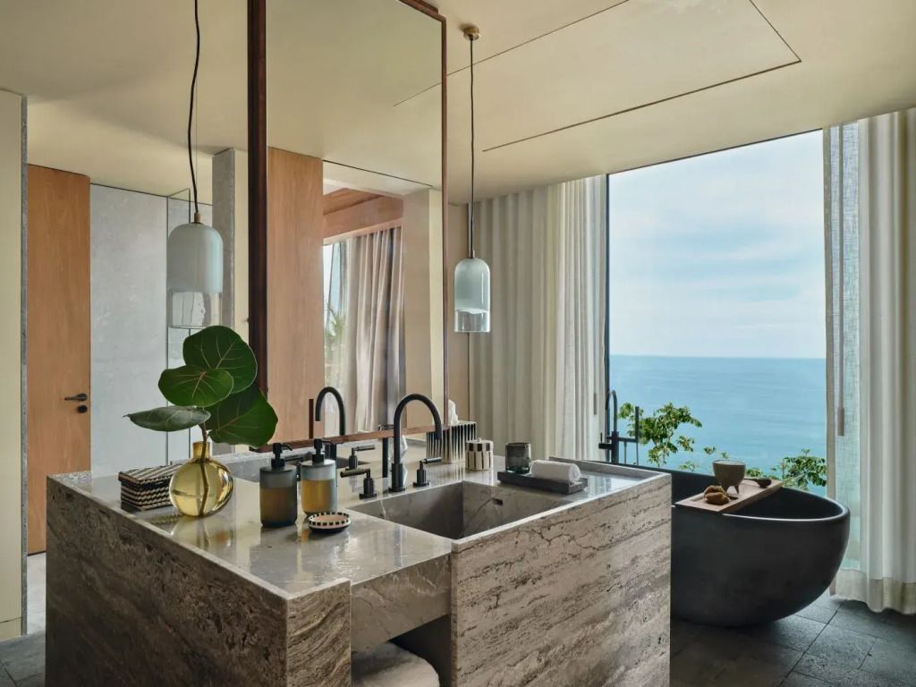 Luxuriöses Badezimmer mit großem Spiegel und Meerblick
