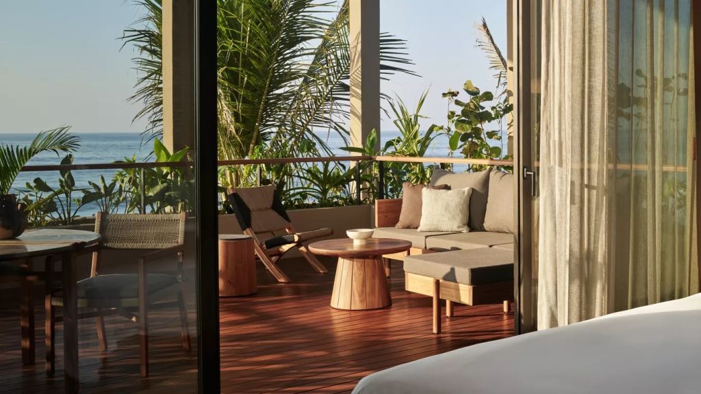 Möblierte Terrasse mit Meerblick und tropischen Pflanzen