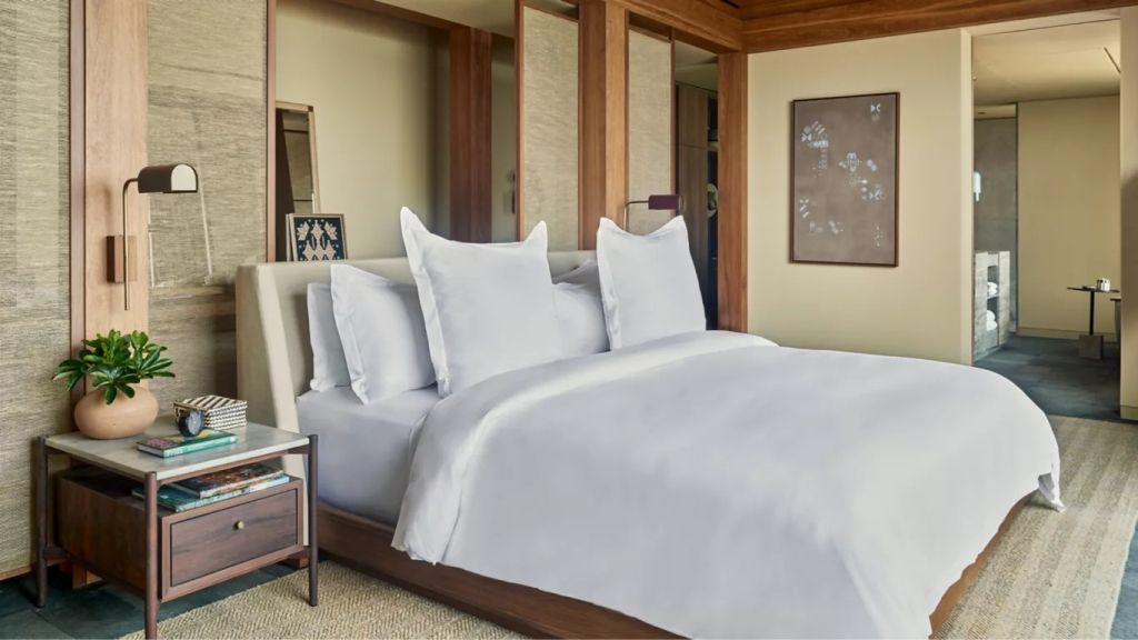 Luxuriöses Doppelbett in Villa mit eleganten Kissen und Holzakzenten