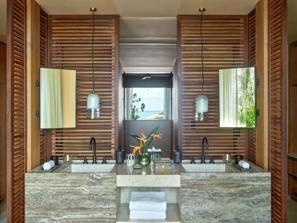 Modernes Badezimmer mit zwei Waschbecken und Holzdetails in der Suite.