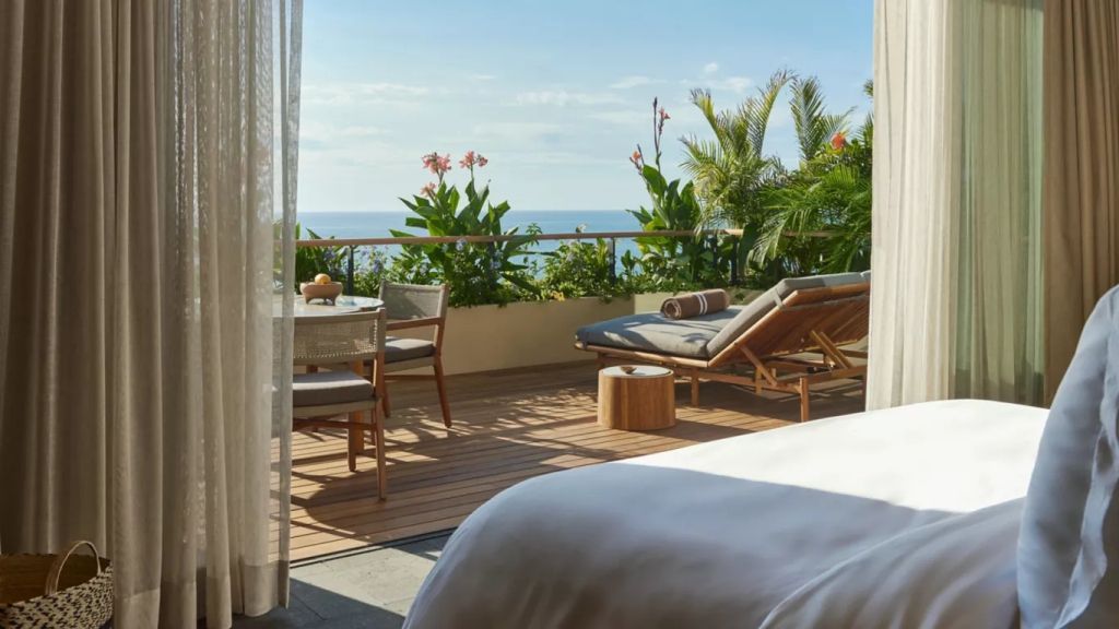 Private Terrasse mit Liegestühlen und Meerblick, reich an Pflanzen