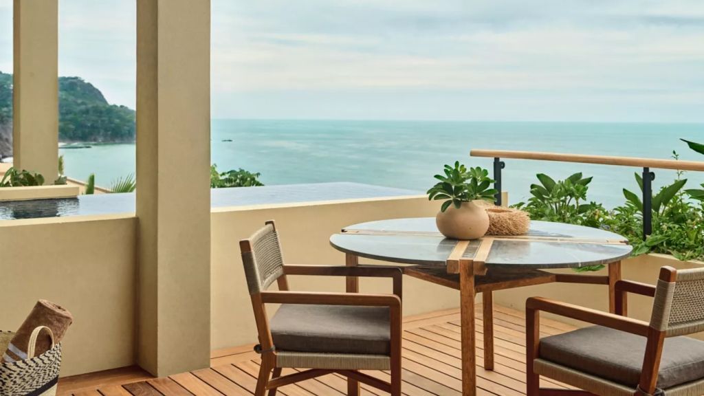 Terrasse mit Tisch und Stühlen, ansprechend dekoriert, mit direktem Meerblick