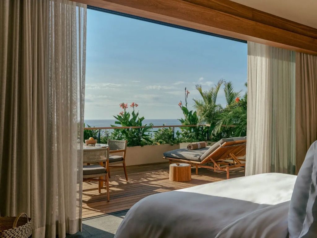 Terrasse mit Meerblick, Liegestuhl und Pflanzen.